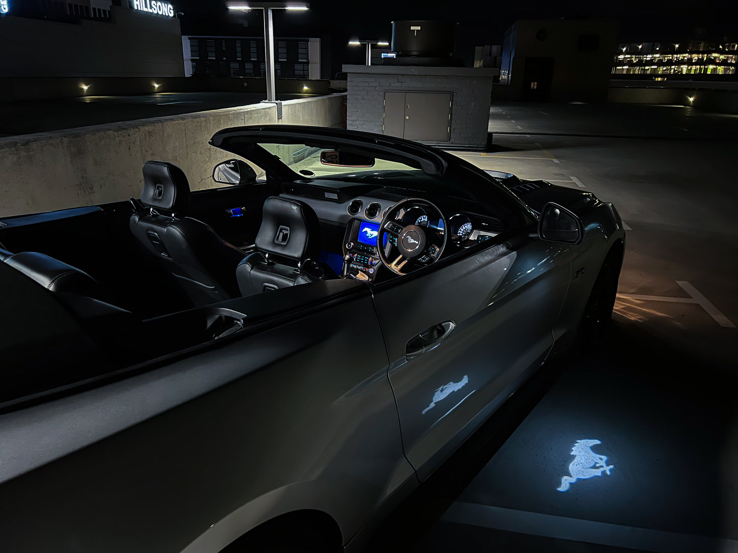 Car interior with glowing logo on the floor at night
