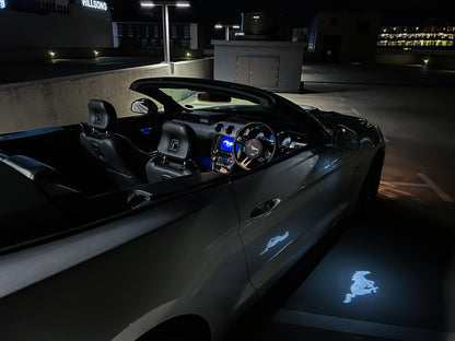 Car interior with glowing logo on the floor at night