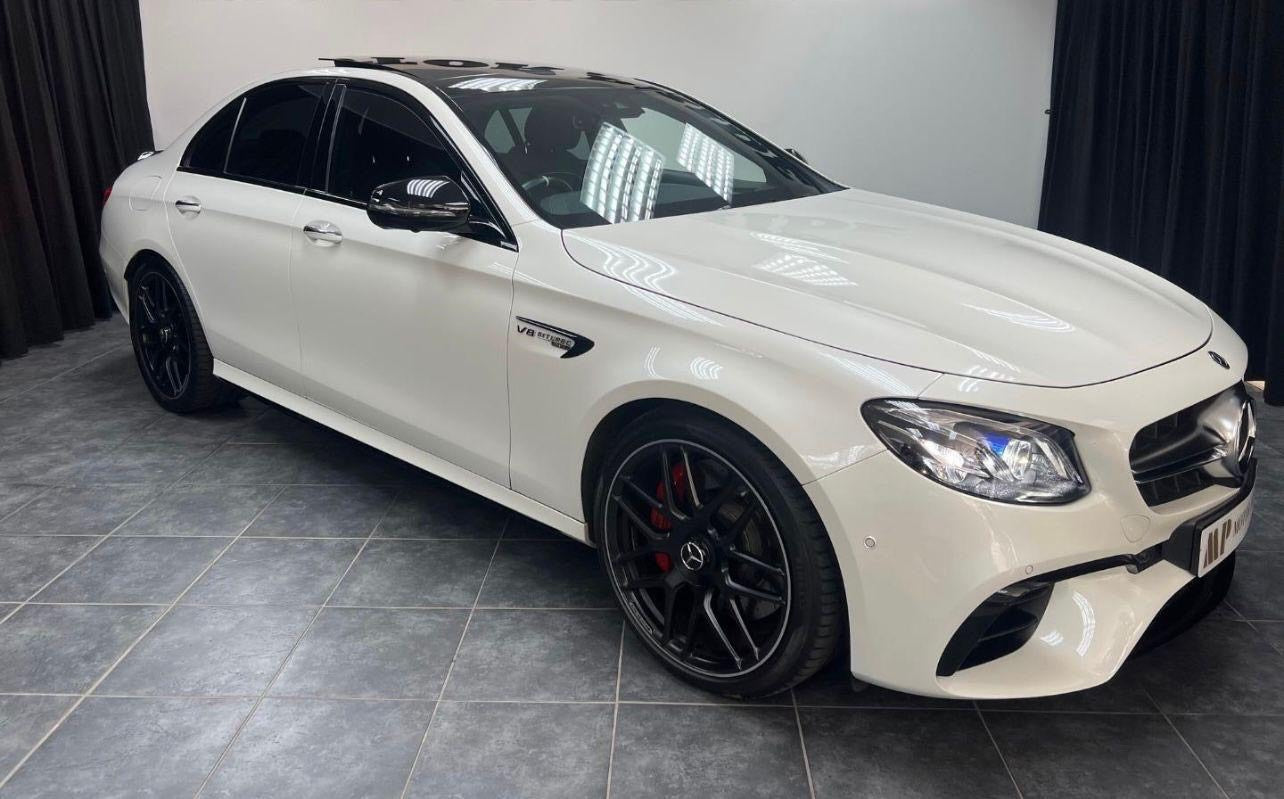 White Mercedes-Benz car on a tiled floor with a neutral background